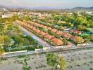 Aerial view of a residential community with aligned houses and green surroundings