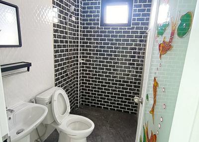 Modern bathroom interior with tiled walls and glass shower cabin