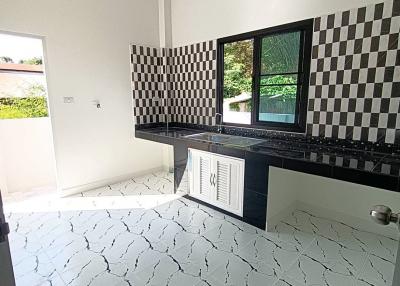Modern kitchen with checkered backsplash and unique tiled flooring
