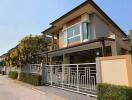 Modern two-story house with spacious balcony and gated entrance