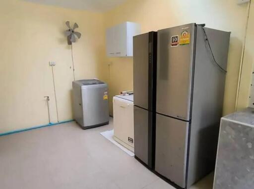Spacious kitchen with large refrigerator and washing machine