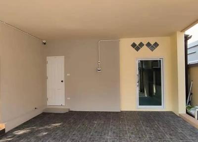 Covered entryway with tiled flooring and a white front door