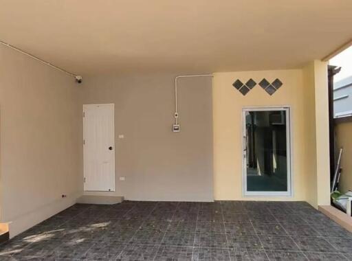 Covered entryway with tiled flooring and a white front door