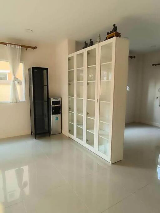 Spacious living room with large white bookshelf and glossy floor tiles