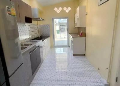 Modern kitchen with stainless steel appliances and white tiled flooring