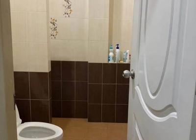 Compact bathroom with toilet and tiled walls