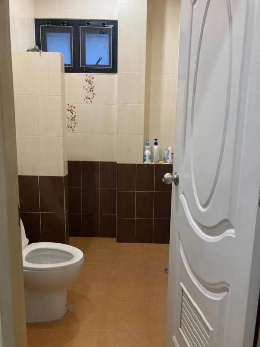 Compact bathroom with toilet and tiled walls