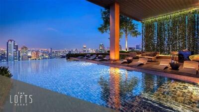 Luxurious rooftop swimming pool with city skyline view at dusk