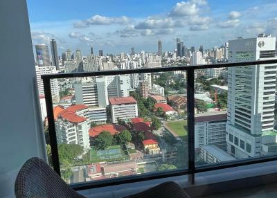 High-rise balcony view overlooking the cityscape with comfortable seating