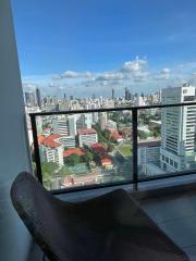 High-rise balcony view overlooking the cityscape with comfortable seating