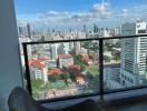 High-rise balcony view overlooking the cityscape with comfortable seating