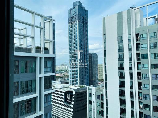 High-rise urban view from a window showing surrounding buildings and clear sky