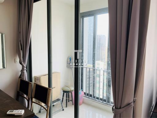 City view from a high-rise apartment with large windows and natural light