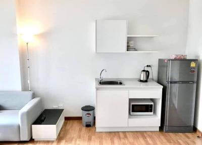 Compact modern kitchen with appliances and sofa
