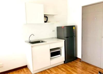 Compact kitchen with modern appliances and white cabinetry