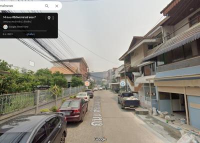 Street view of a residential area with houses and parked cars