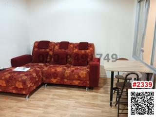 Cozy living room with red patterned sofa and wooden flooring