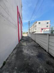 Narrow Alleyway Next to a Building with a Pink Accent