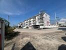 Exterior view of a multi-story apartment complex with parking area