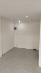 Spacious empty room with tiled floor and bright ceiling lights