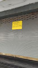 Metal shutter of a closed commercial space with contact information sign