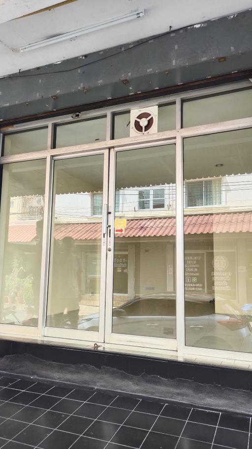 Exterior view of a commercial storefront with large glass windows and entrance door