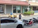 Street view from property showing parking area and commercial establishments