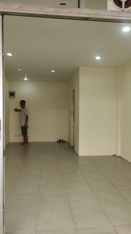 Spacious empty interior of a residential building with tiled floors and bright lighting