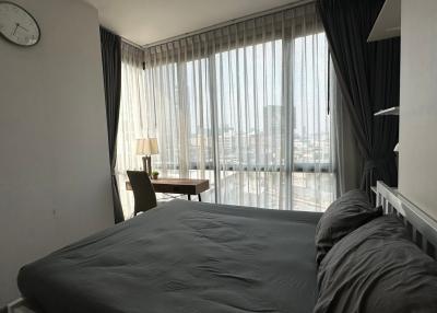 Modern bedroom with large windows and city view