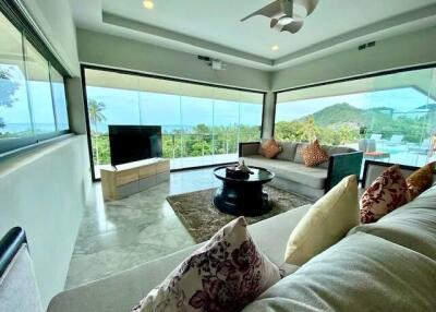 Spacious living room with modern furniture and panoramic windows overlooking the nature