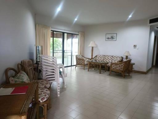 Spacious and brightly lit living room with comfortable seating and balcony access