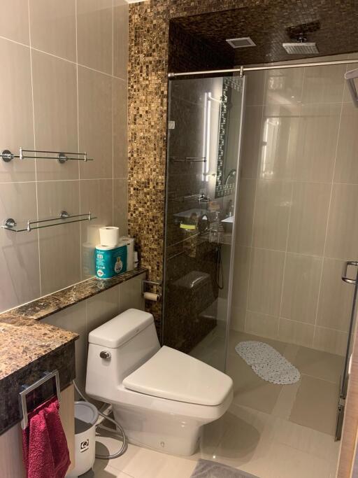 Modern bathroom with glass shower and mosaic tile accents