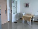 Minimalist dining area with white cabinetry and tiled flooring