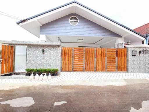 Contemporary house exterior with stylish wooden gate and stone wall