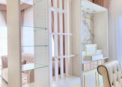 Elegant white-themed living room with glass shelving and modern decor