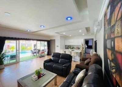 Spacious living room with modern furniture leading to an outdoor pool area