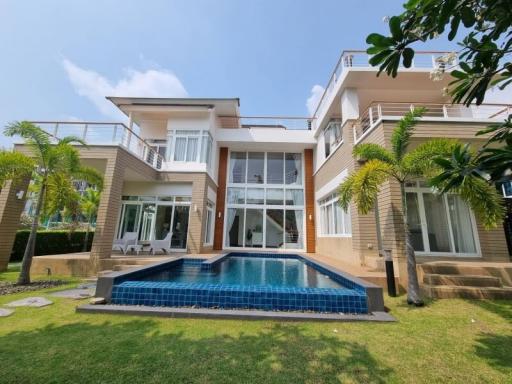 Luxurious two-storey house with a swimming pool and lush green lawn