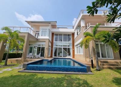 Luxurious two-storey house with a swimming pool and lush green lawn