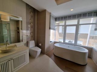Spacious modern bathroom with freestanding tub and large window