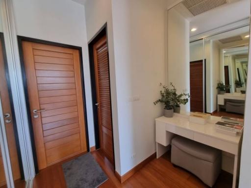 Spacious bedroom with modern vanity area and wooden accents