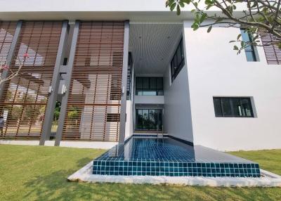 Modern two-story house with exterior wooden slats and a front pool