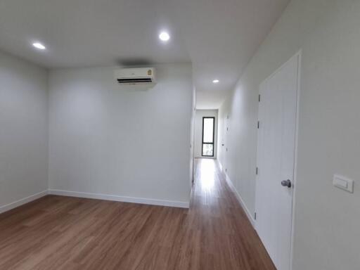 Spacious and well-lit empty bedroom with wooden flooring