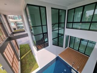 View of a modern building exterior with a private pool and balcony