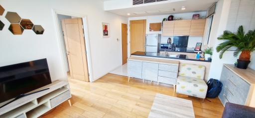 Comfortable living room with modern open kitchen, wooden flooring, and natural light