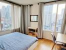 Modern bedroom with a city view, featuring a large bed, desk, and hardwood floors