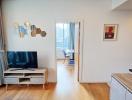 Bright and modern living room with a flat-screen TV and balcony access