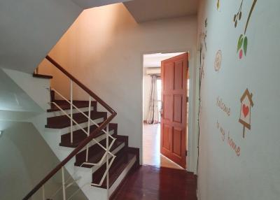 Cozy stairway with artistic wall decorations leading to brightly lit upper level