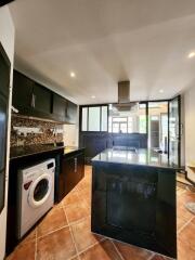 Modern kitchen with black cabinets and stainless steel appliances