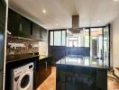 Modern kitchen with black cabinets and stainless steel appliances