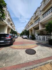 Quiet residential street with townhouses and parked cars